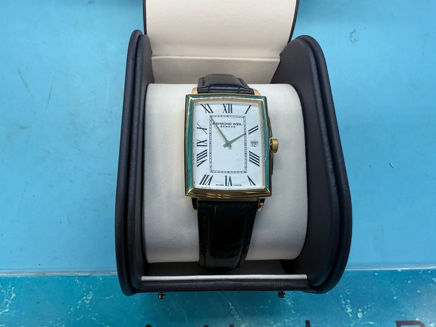 Close-up of Raymond Weil Toccata white dial face showing hour markers, hands